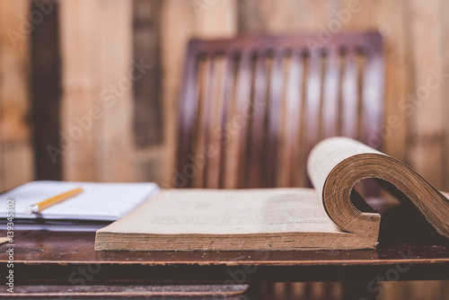 Old book on wooden table,abstract image of open antique book on wooden table