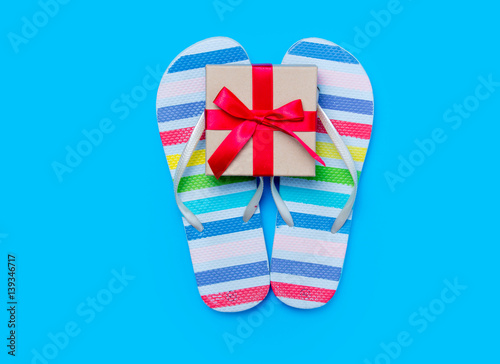 colorful sandals and cute small gift on the wonderful blue background © Masson