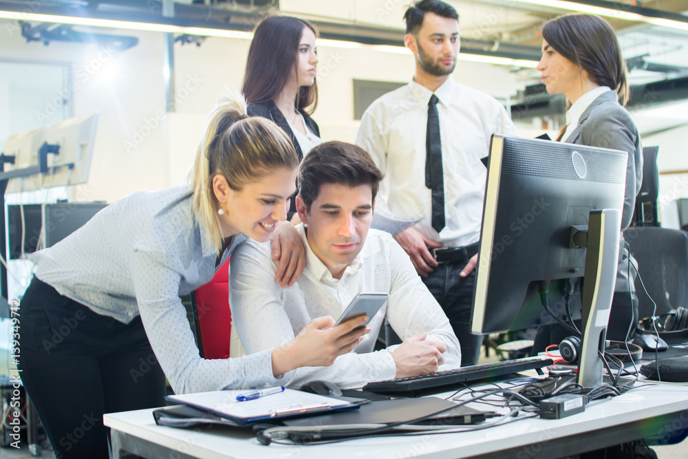 Businesswoman and businessman looking at smartphone office.