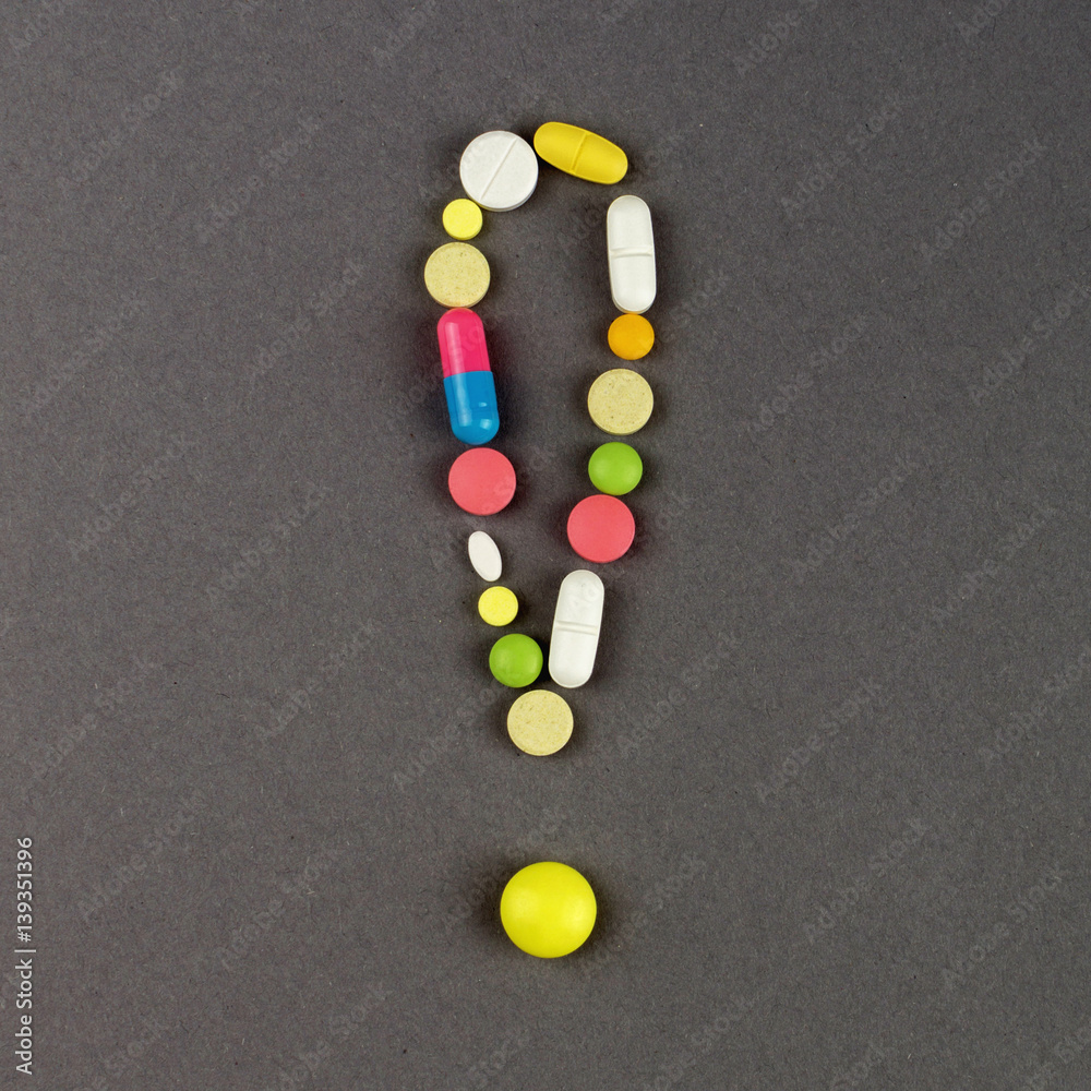 Exclamation point created from colored pills. Medical concept