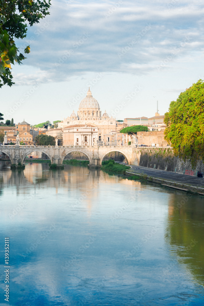 St. Peter's cathedral over bridge and river Tiber water in Rome, Italy