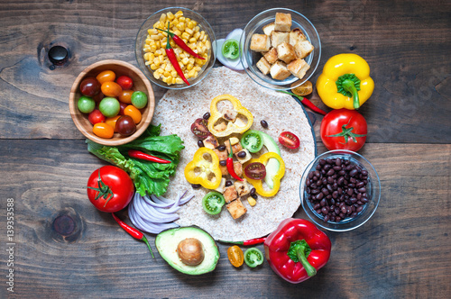 Tortilla wrap or burrito with tofu, greens, and vegetables, vegetarian healthy food, toned image