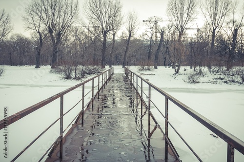 Frozen old pier at river side in winter time. Stock image. © kolidzei