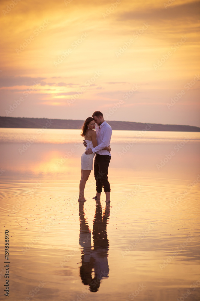 Loving couple embracing standing in water