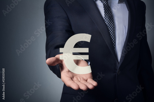 businessman holding currency symbol in hands. Hand holding euro symbol.