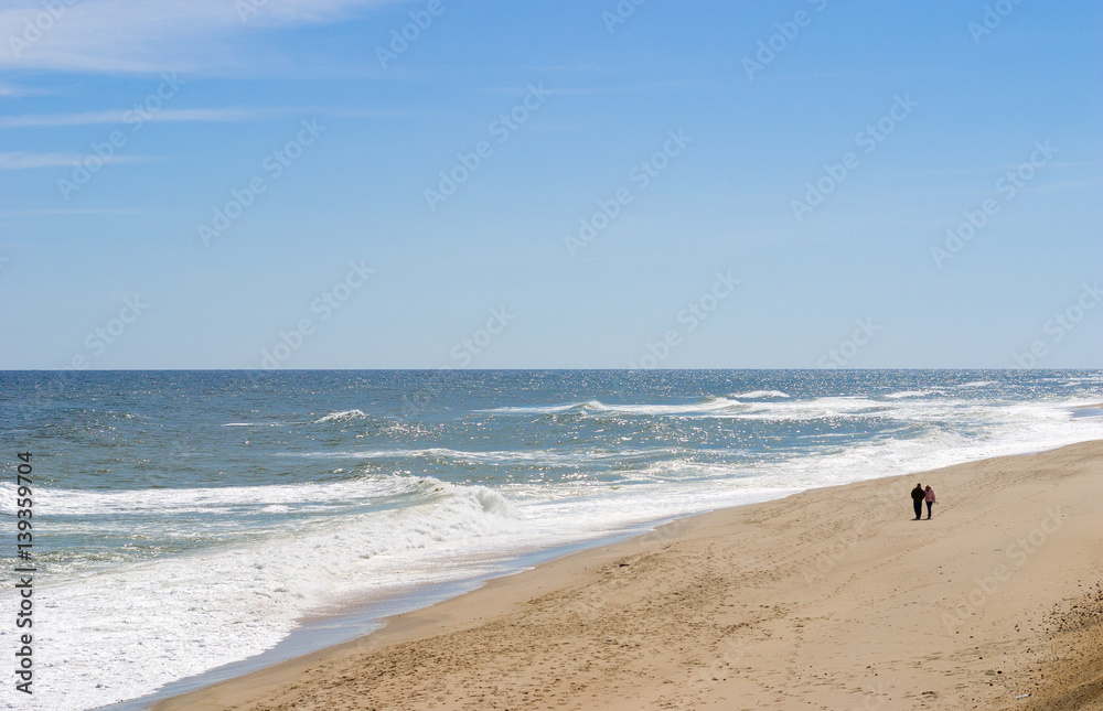 couple walking along seashore at Cape Cod couple walking along seashore at Cape Cod