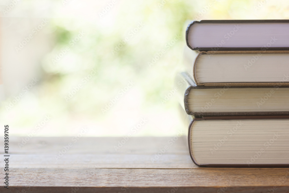 stack of thick books with green light and bokeh background stack of thick books with green light and bokeh background