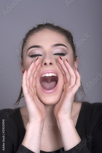 Young woman shouting with hands cupped around the mouth