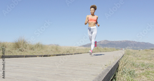 Young pretty woman training her stamina on the pavement in Tarifa beach, Cadiz, Spain. Horizontal outdoors shot. 
