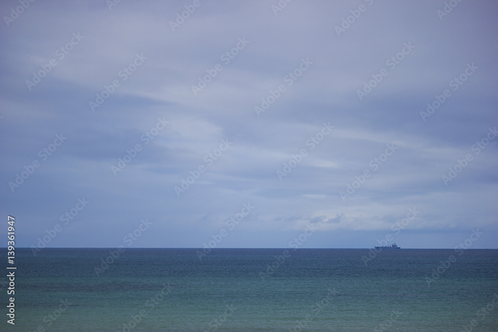 Ship on the ocean horizon with sky and clouds