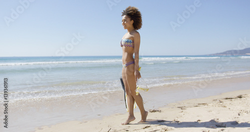 Smiling female wearing two-piece swimsuit standing with flippers on Tarifa beach. Provincia Cadiz. Spain.  © Dash