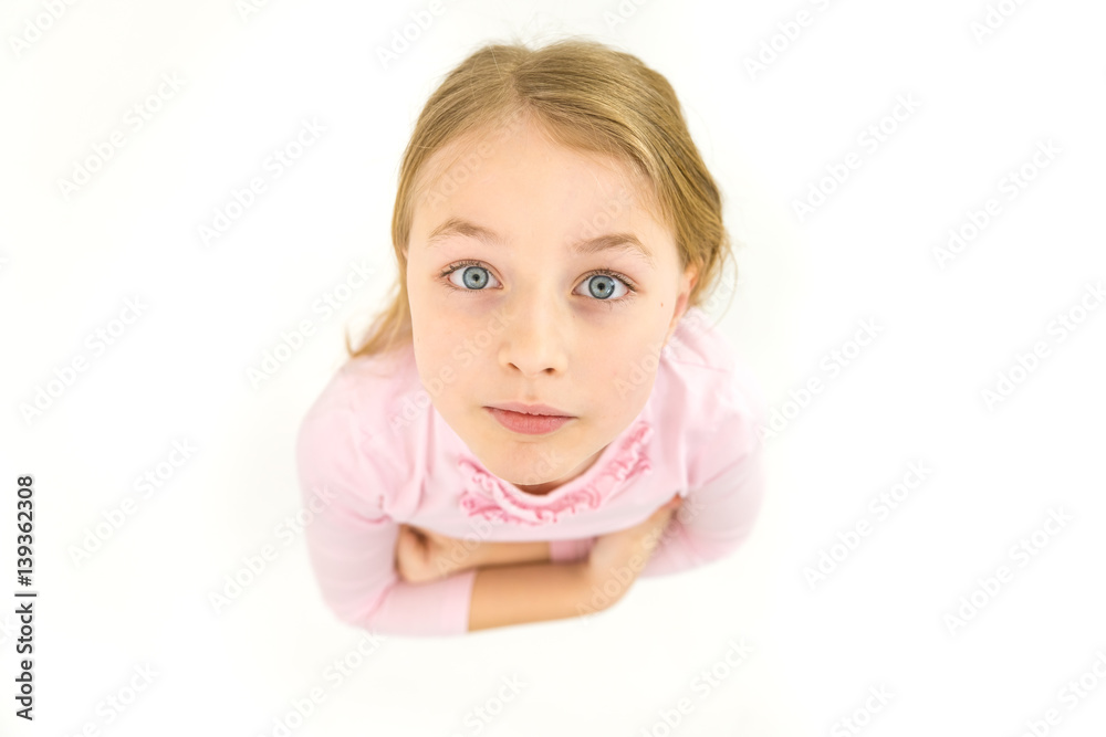 The girl look to the camera on the white background. View from above The girl look to the camera on the white background. View from above