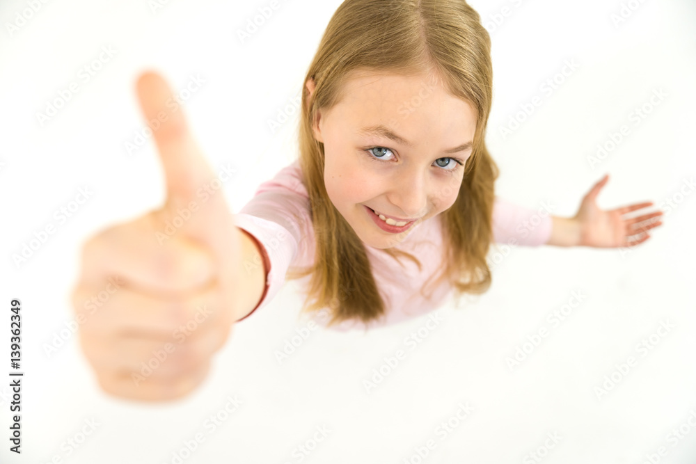 The happy girl thumbs up to the camera. View from above The happy girl thumbs up to the camera. View from above
