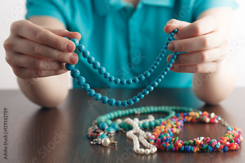 girl holds a pile of jewelry