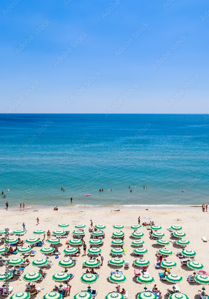 The Black Sea shore, blue clear water, beach with sand, umbrellas and sunbeds. Albena, Bulgaria The Black Sea shore, blue clear water, beach with sand, umbrellas and sunbeds. Albena, Bulgaria