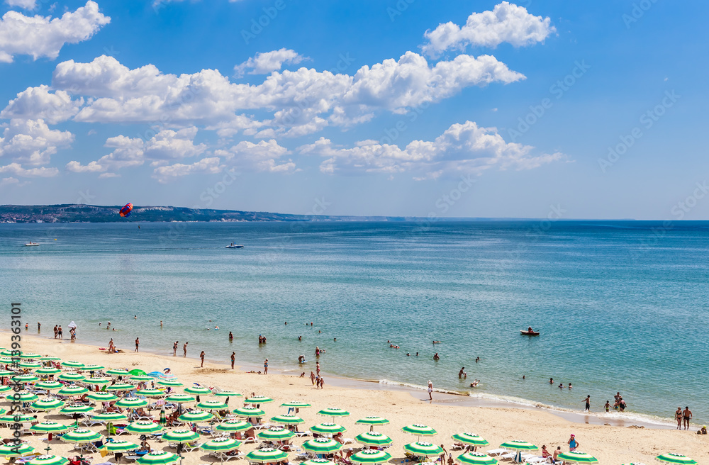 The Black Sea shore, blue clear water, beach with sand, umbrellas and sunbeds. Albena, Bulgaria The Black Sea shore, blue clear water, beach with sand, umbrellas and sunbeds. Albena, Bulgaria