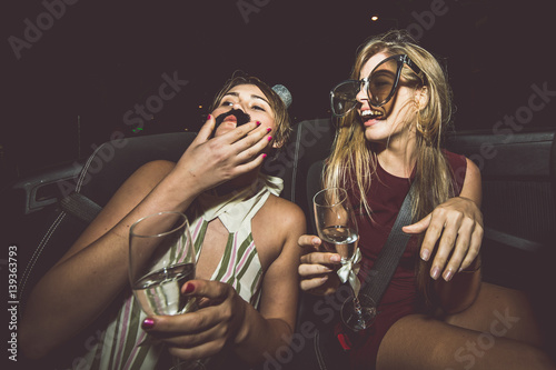 Canvas Print Party girls celebrate in Hollywood drinking champagne on a covertible car