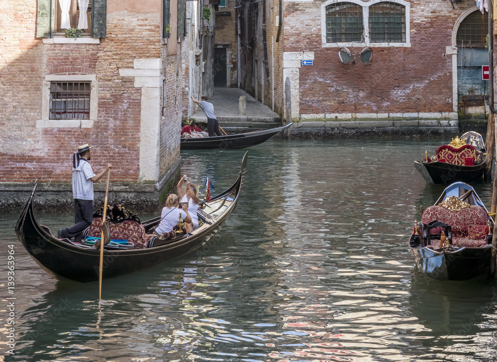 Gondola traffic in a canal in the historic center of Venice, Italy