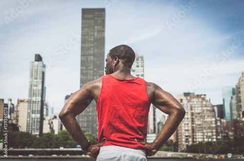 Urban runner looking New york skyline while taking a break