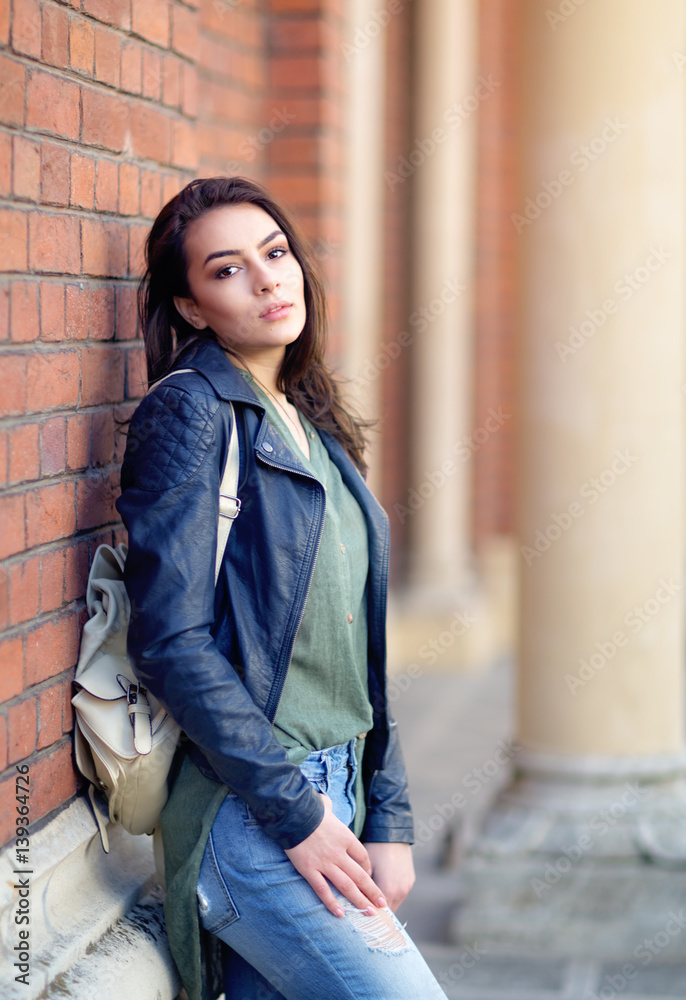 Young woman sitting against the wall. On the streets of town Young woman sitting against the wall. On the streets of town