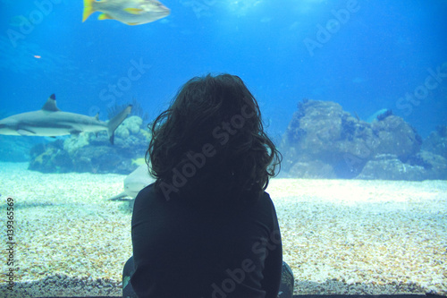 little girl watching fishes in a Oceanarium. Lisbon in Portugal photo