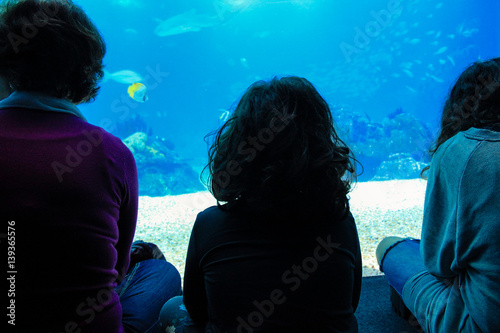 little girl watching fishes in a Oceanarium. Lisbon in Portugal