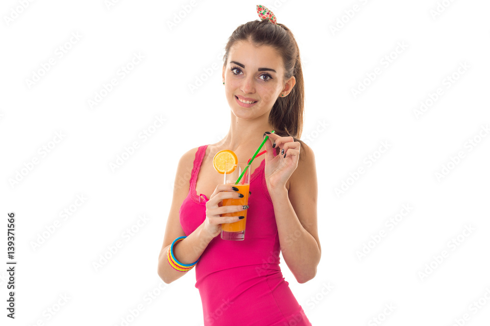 beautiful young girl in a pink shirt smiling and holding a glass of fruit juice beautiful young girl in a pink shirt smiling and holding a glass of fruit juice