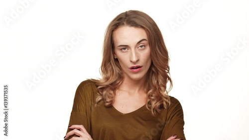 Bored middle-aged Caucasian female with long brown hair looking at camera raising eyebrow on white background photo