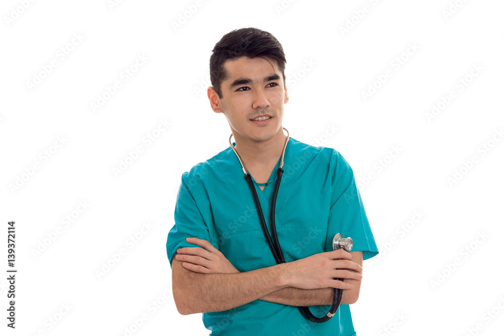 a young doctor in the blue dress with stethoscope folded hands together and smiling a young doctor in the blue dress with stethoscope folded hands together and smiling