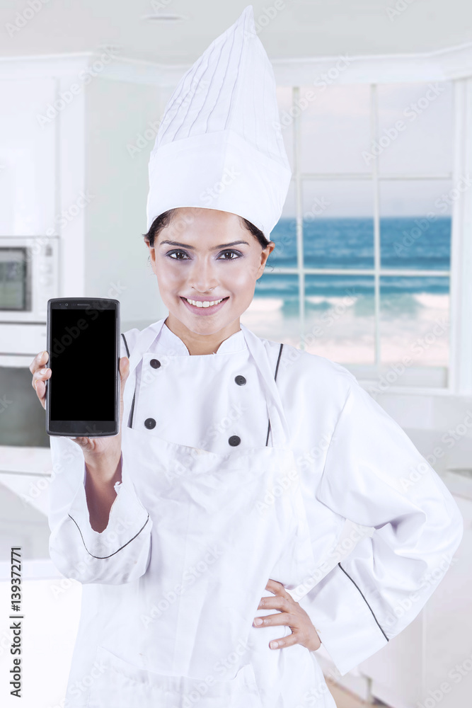 Beautiful chef showing blank cellphone screen