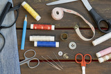 Sewing tools and acessories on brown wooden background