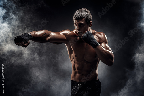 Muscular topless fighter in boxing gloves