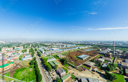 Aerial city view with crossroads and roads, houses, buildings, parks and parking lots, bridges. Copter shot. Panoramic image.