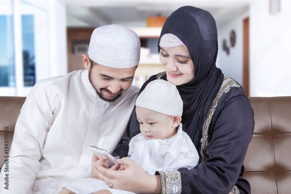 Muslim parents and child using cellphone