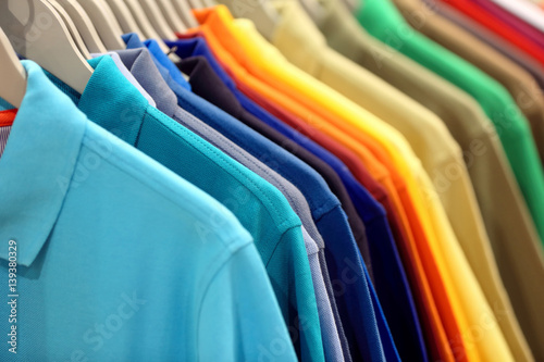 Row of men's polo shirts in wardrobe or store photo