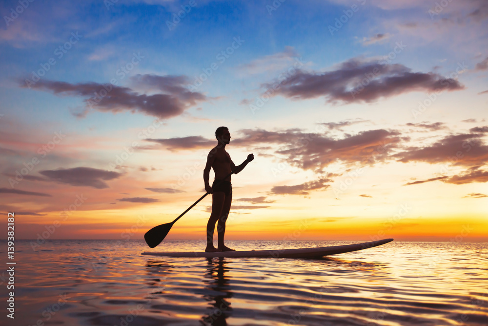paddle standing board, beach leisure activity, beautiful silhouette of man at sunset