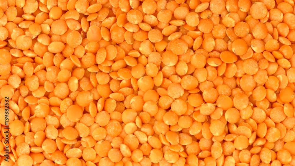 Red lentil rotation background. Healthy raw organic yellow lentils closeup Red lentil rotation background. Healthy raw organic yellow lentils closeup