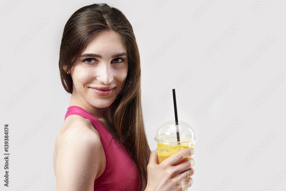Portrait of sporty young caucasian woman holding plastic glass of orange juice Portrait of sporty young caucasian woman holding plastic glass of orange juice