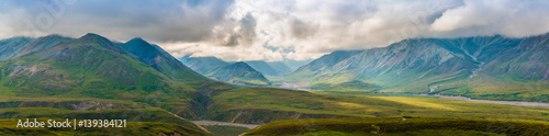 Panoramic landscape of Denali National Park with grass,clouds and sunlight