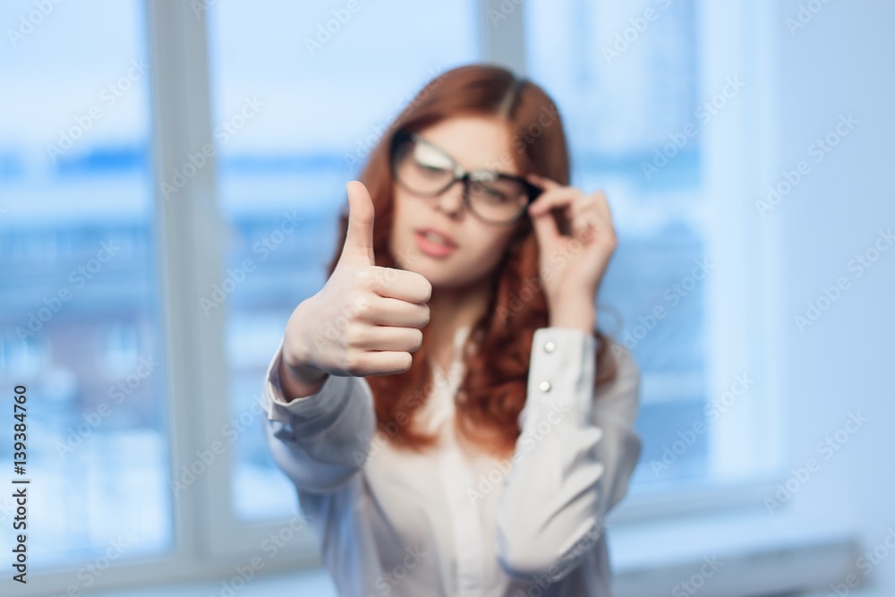thumbs up, an approving gesture, a beautiful woman in the office thumbs up, an approving gesture, a beautiful woman in the office