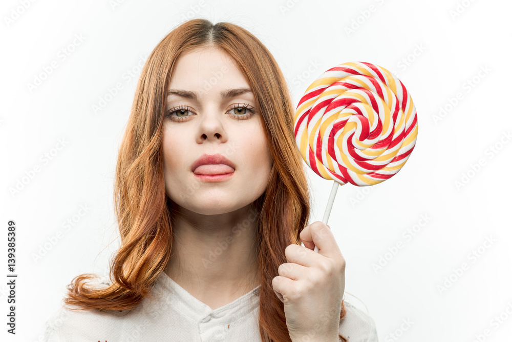 red-haired woman with a round candy in her hand
