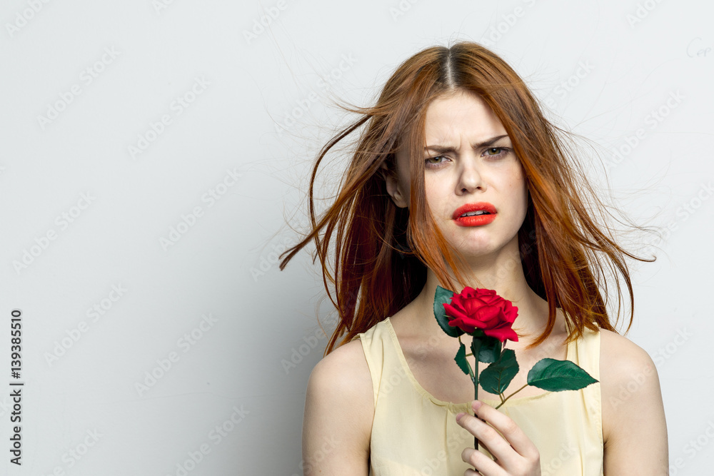 sullen woman with red lips holds a rose in her hand sullen woman with red lips holds a rose in her hand