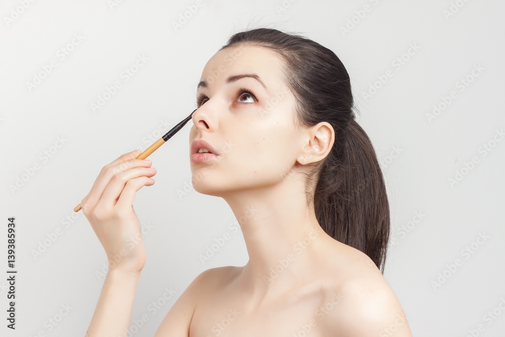 woman looking up, makeup brush, skin care woman looking up, makeup brush, skin care
