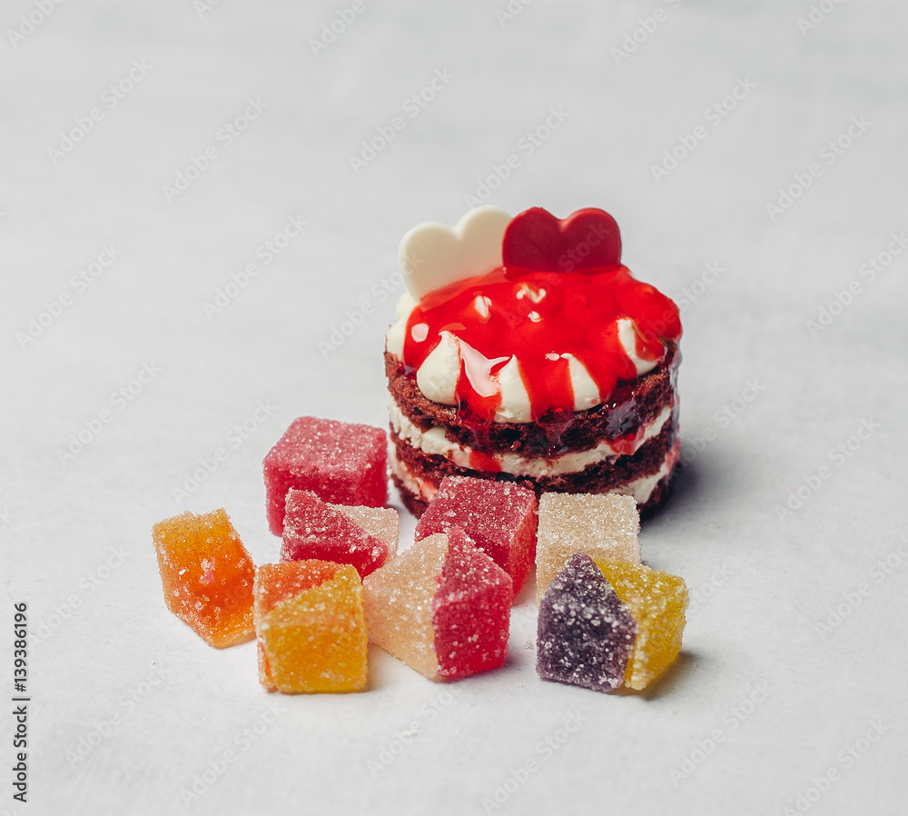 a cake on the table and a multicolored marmalade a cake on the table and a multicolored marmalade