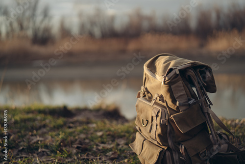 Traveler's backpack on nature, river, grass