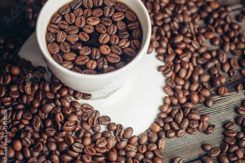 Coffee beans in a cup and on a table