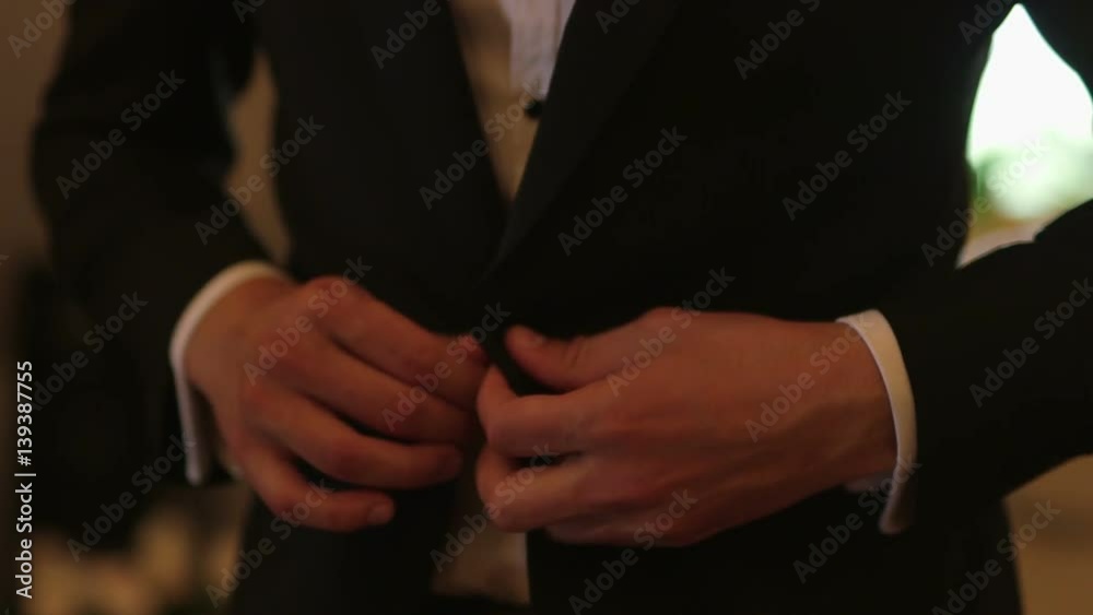 Groom Fastening Button On His Jacket