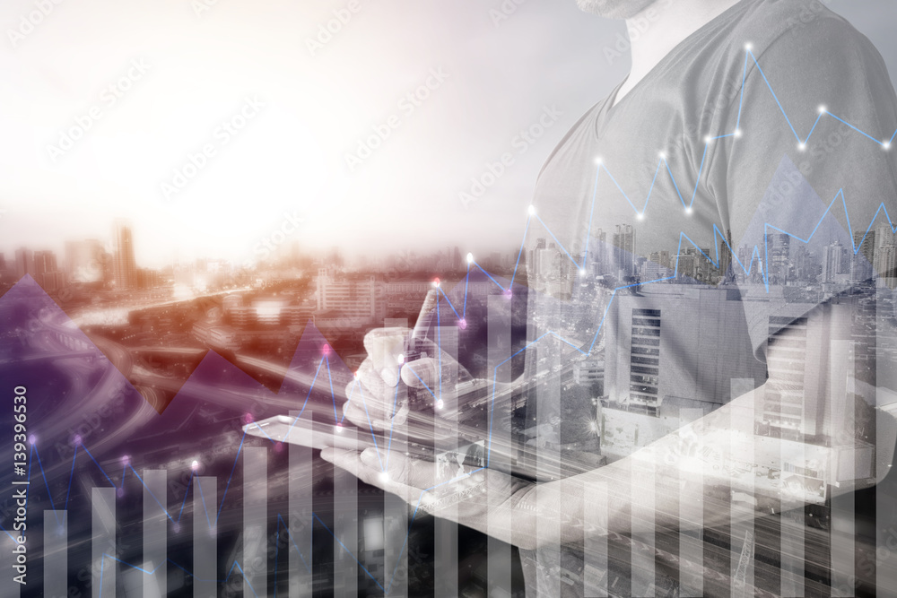 Double exposure of businessman using digital tablet with city landscape blurred background.Forex graph on the business city centre. A metaphor of international financial consulting.investment concept