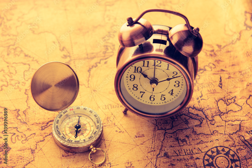 Compass and alarm clock classic style on old map,vintage process tone style Compass and alarm clock classic style on old map,vintage process tone style