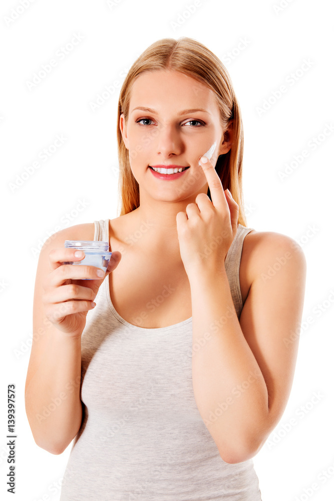 Portrait of young woman applying moisturizer cream on her pretty face Portrait of young woman applying moisturizer cream on her pretty face